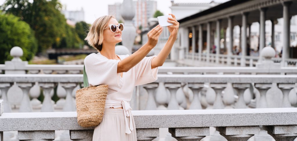 Happy female using smart phone on the Triple bridge in Ljubljana